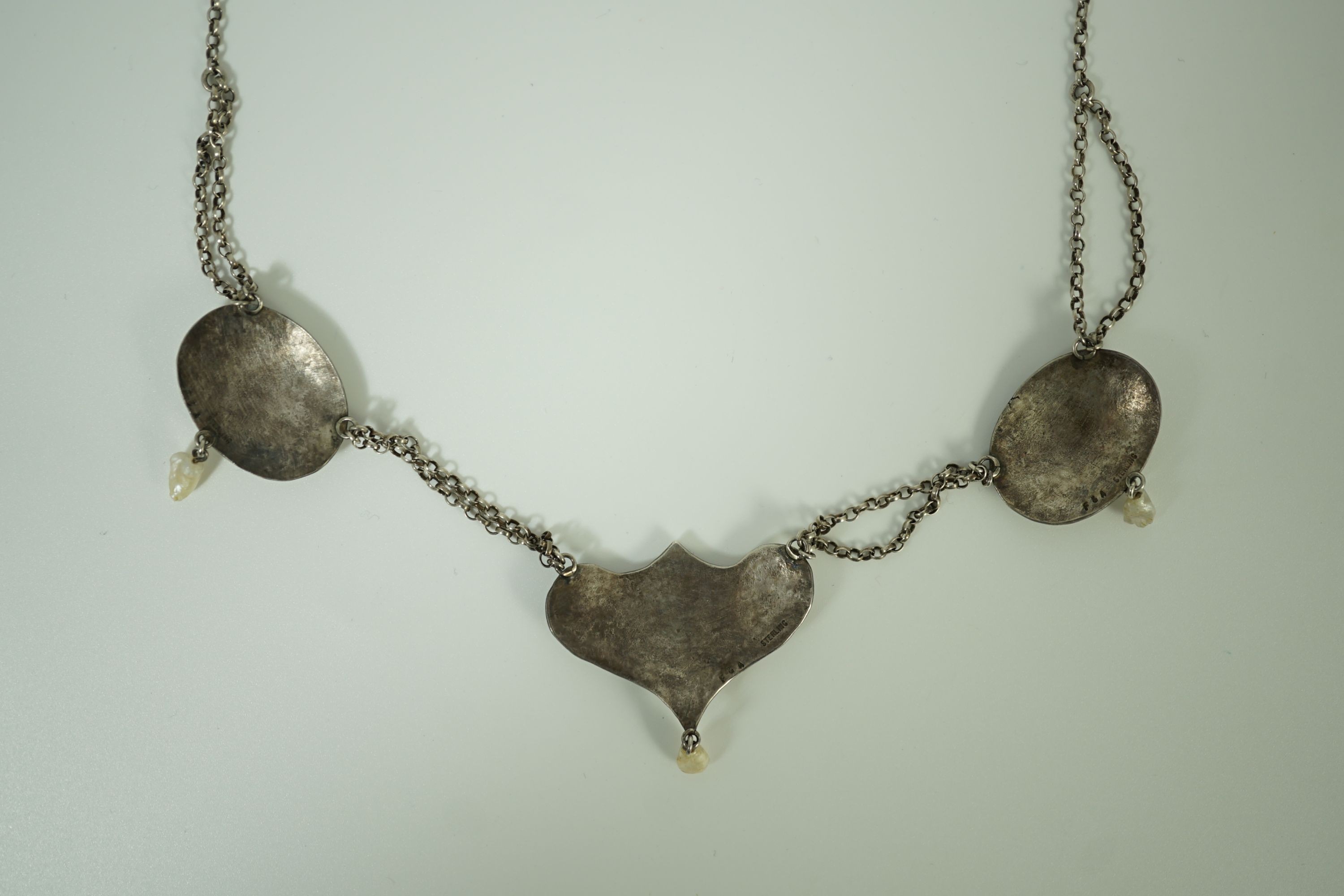 A stylish early 20th century sterling, enamel and baroque drop pearl set necklace